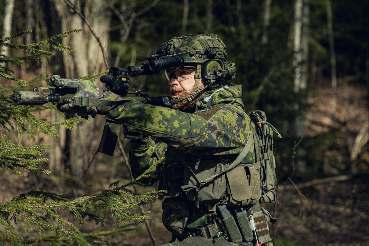 Man in the forest holding an AR 15 and dressed in Varusteleka gear, including the L3 Softshell