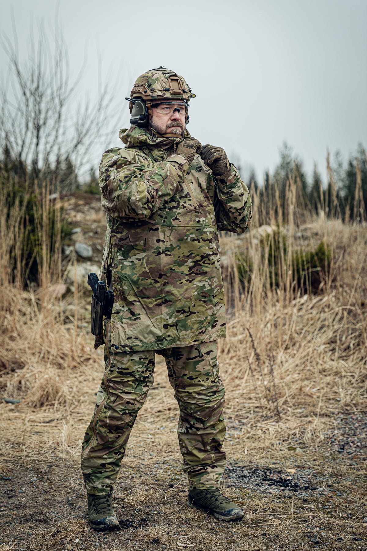 Person in camouflage military uniform standing in a natural setting
