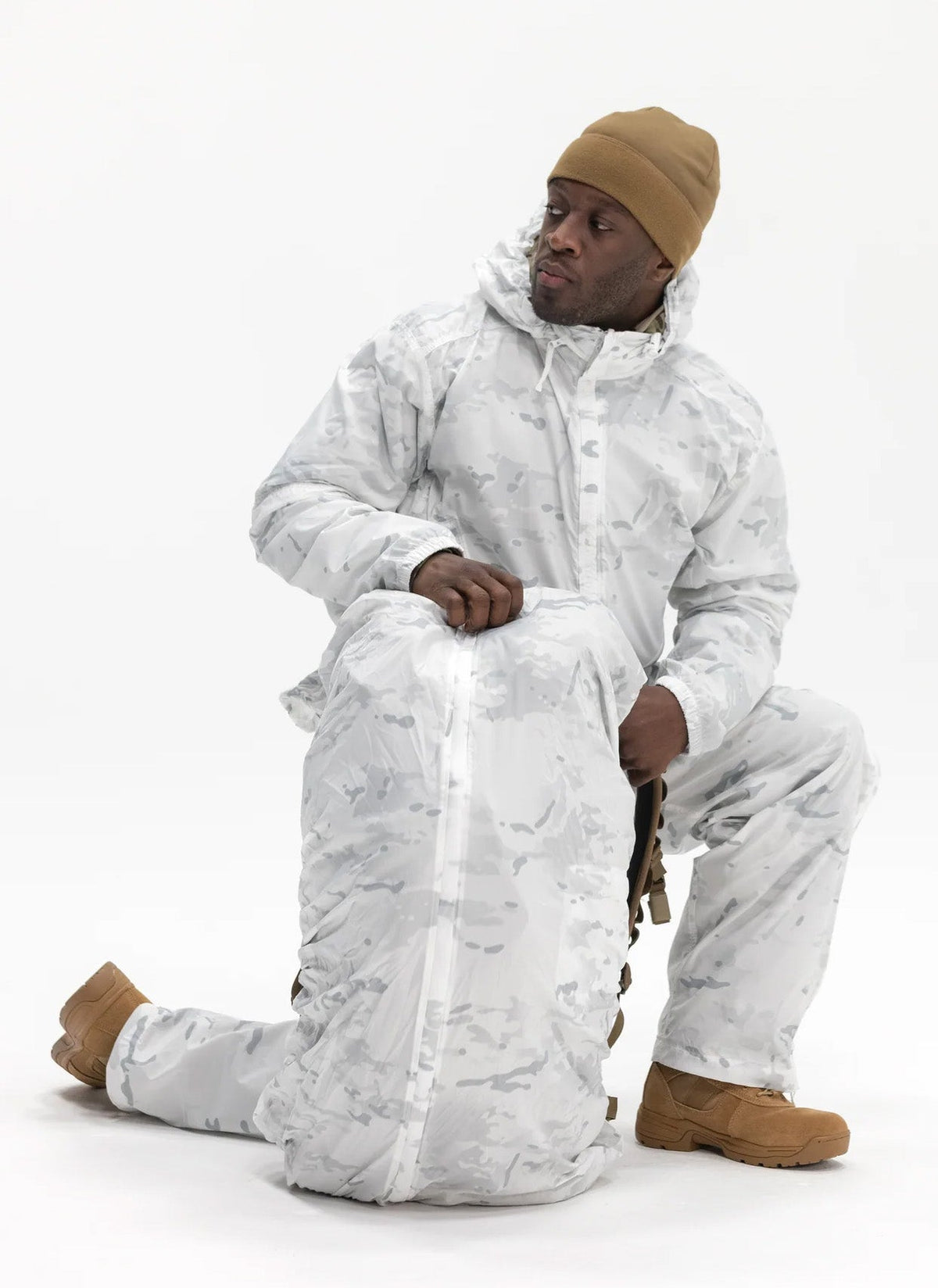 A person in snow camo outfit handling a snow camo pack covered rucksack.
